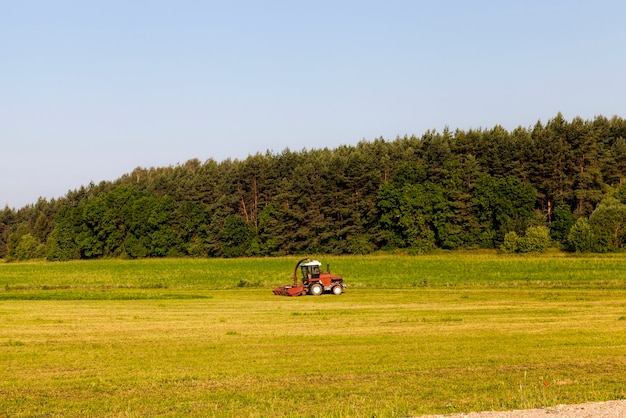 Campo agricolo con trattore vicino alla foresta