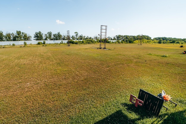 Campo di addestramento per fucili vuoto con erba verde e macchine plat