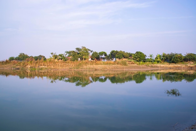 Canale con alberi e vegetazione riflessa nell'acqua vicino al fiume Padma in Bangladesh