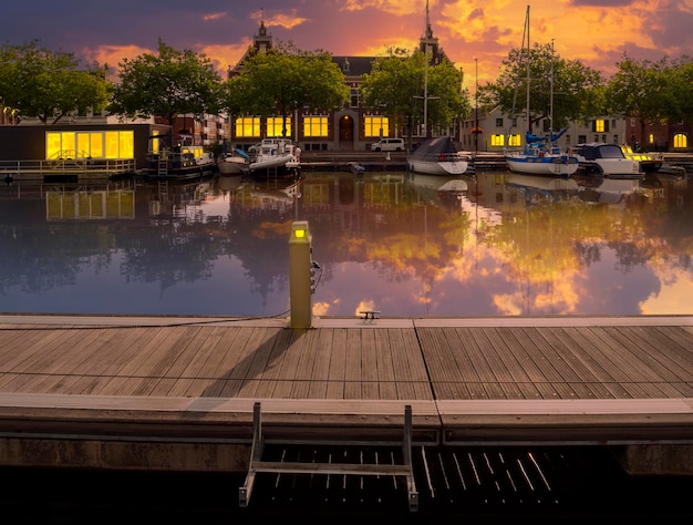 Canale con barche ed edifici illuminati da lanterne e luce dalle finestre dei Paesi Bassi