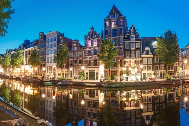 Canale di Amsterdam herengracht con tipiche case olandesi e i loro riflessi durante l'ora blu del mattino