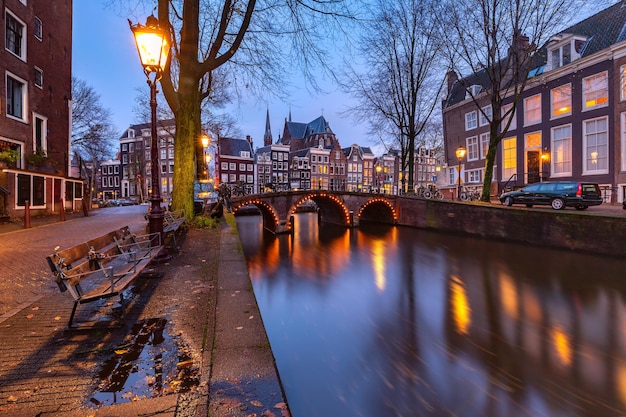 Canale di Amsterdam leidsegracht con tipiche case olandesi e ponte durante l'ora blu serale holland n...