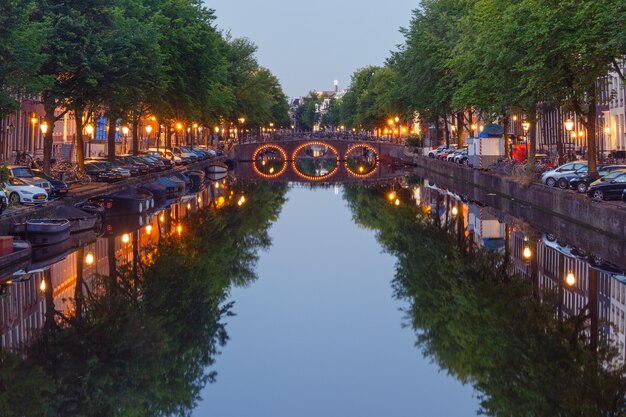 Canale di Amsterdam, ponte e tipiche case, barche e biciclette durante l'ora blu mattutina, Olanda, Paesi Bassi