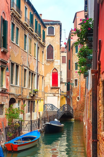 Canale laterale stretto variopinto a venezia con la barca ancorata italia