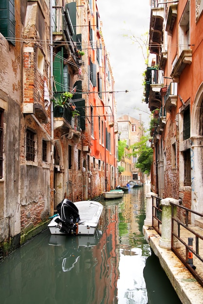 Canale stretto con barche a Venezia, Italy