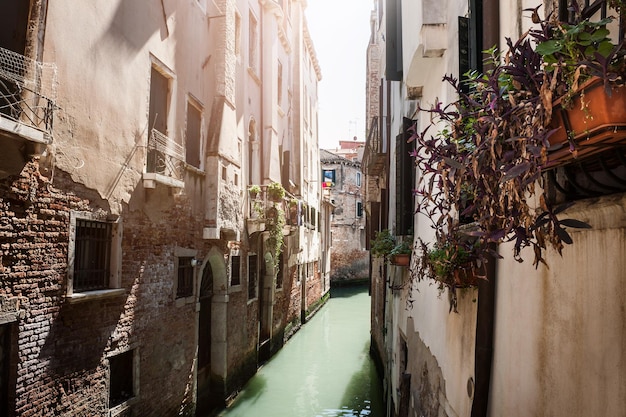 Canale stretto scenico con le costruzioni antiche a Venezia, Italia.