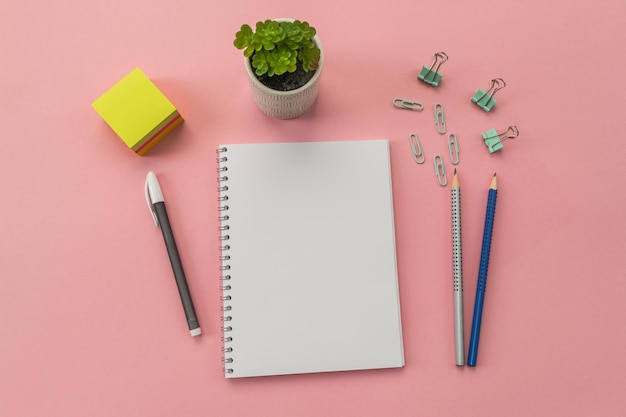Cancelleria penna notebook su sfondo rosa Immagine concettuale