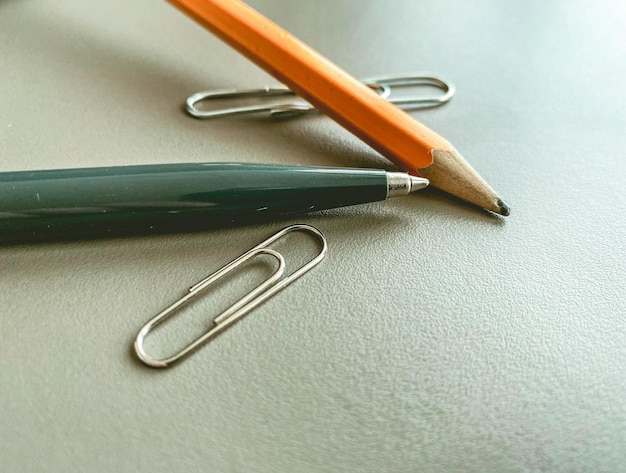 Cancelleria sul tavolo in ufficio una penna di metallo blu per scrivere una semplice matita di legno con piombo