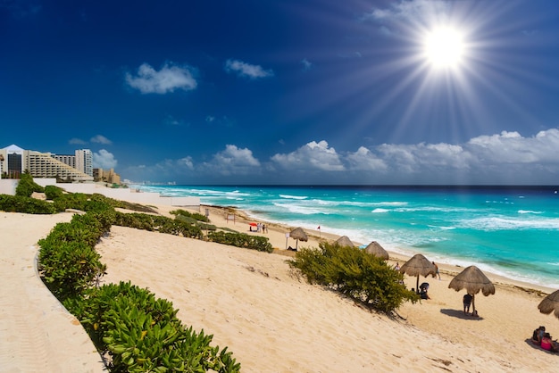 CANCUN MESSICO APR 2022 Ombrelli su una spiaggia sabbiosa con acqua azzurra in una giornata di sole vicino a Cancun Messico