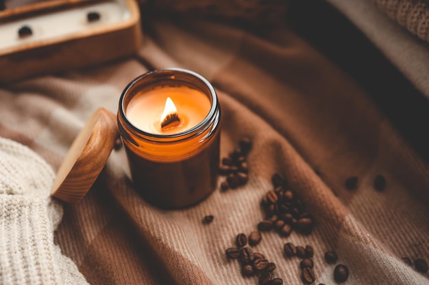 Candela accesa e chicchi di caffè foto accogliente