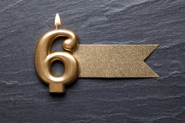 Candela celebrativa numero 6 in oro con etichetta glitter