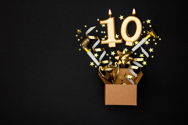 Candela di celebrazione dell'oro numero 10 e sfondo della confezione regalo