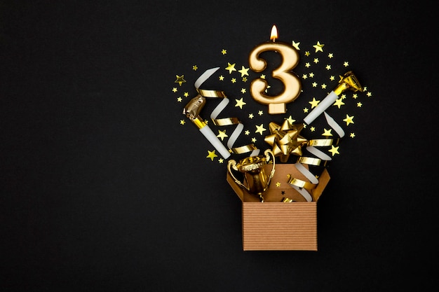 Candela di celebrazione dell'oro numero 3 e sfondo di scatola regalo