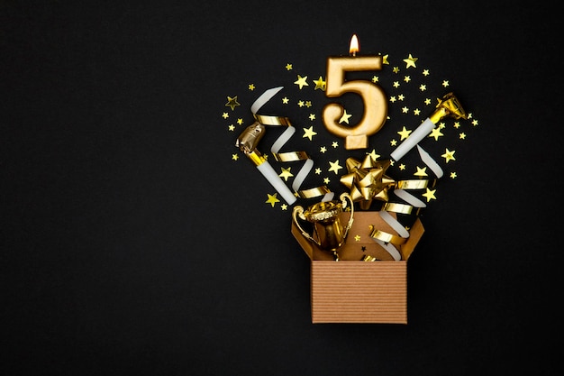 Candela di celebrazione dell'oro numero 5 e sfondo di scatola regalo