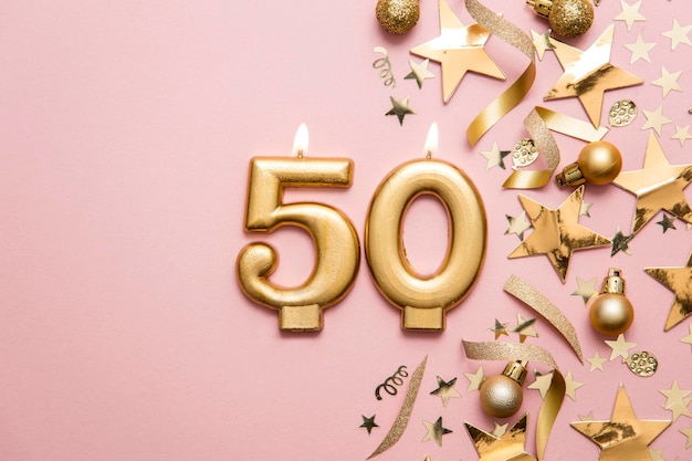 Candela di celebrazione dell'oro numero 50 su sfondo stellato e glitter