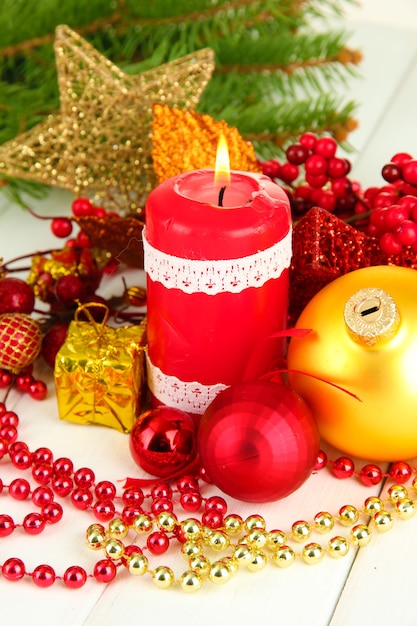 Candela rossa con decorazioni natalizie su sfondo chiaro