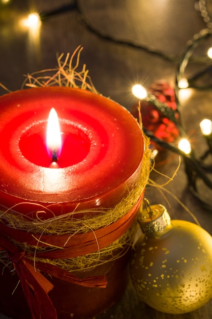 Candela rossa di natale ed ornamenti di natale sul primo piano di legno