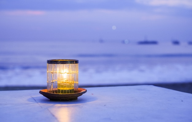 Candela sull'oceano al tramonto