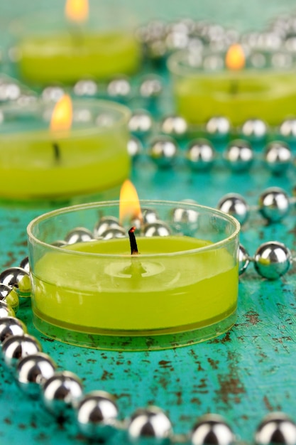 Candele accese con perline su sfondo verde