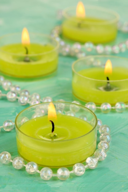 Candele accese con perline su sfondo verde