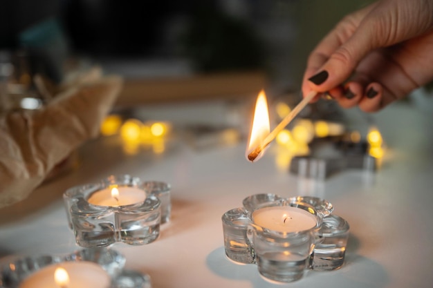 Candele accese in candelabri di vetro con un fiammifero acceso
