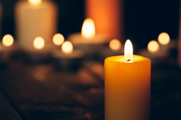 Candele accese nell'oscurità sul nero. concetto di commemorazione.