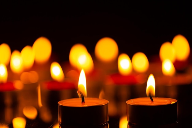 candele accese sulla superficie scura del giorno commemorativo Candele accese nell'oscurità
