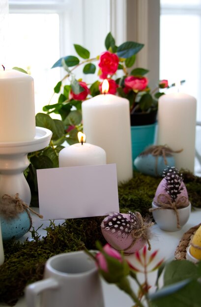 Candele bianche e uova di pasqua festive e spazio bianco per la copia della carta