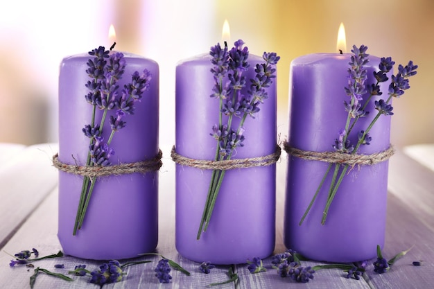 Candele con fiori di lavanda su sfondo luminoso