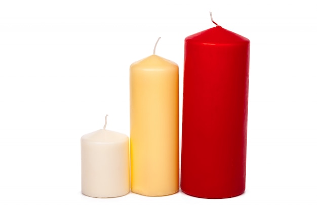 Candele differenti di colori e di dimensione isolate su un bianco