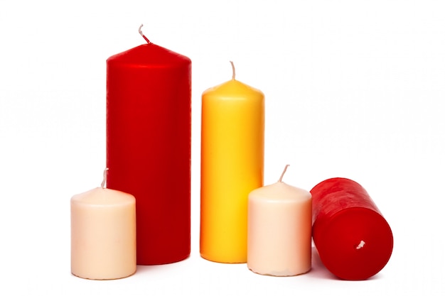 Candele differenti di colori e di dimensione isolate su un bianco