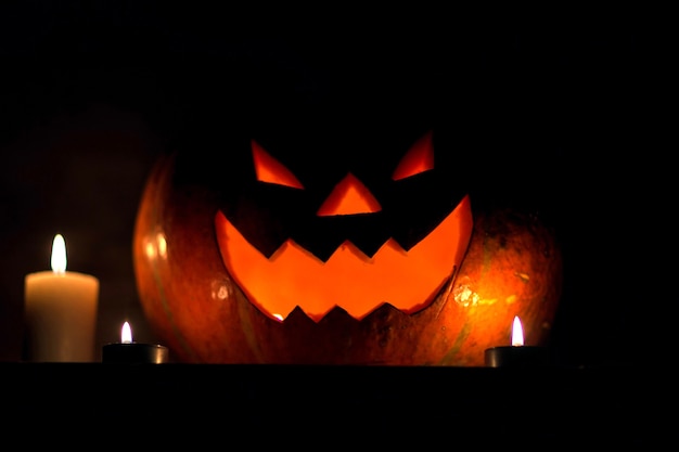 Candele e zucca per Halloween su sfondo scuro.foto con copia spazio