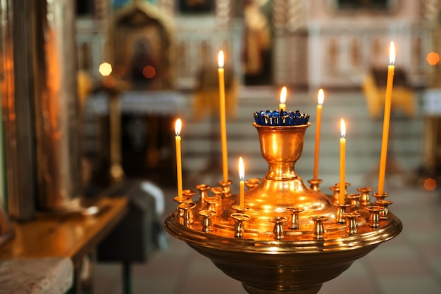 Candele gialle brucianti nella chiesa ortodossa