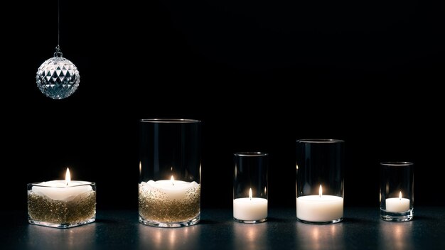 Candele luminose in bicchieri su un banner a superficie nera riflettente