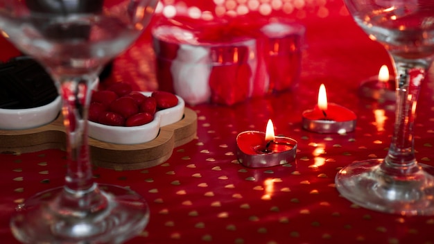 Candele per San Valentino, tavolo con sfondo rosso festivo.