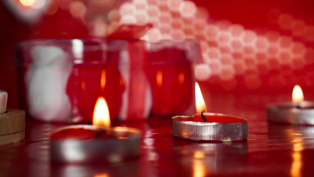 Candele per San Valentino, tavolo con sfondo rosso festivo.