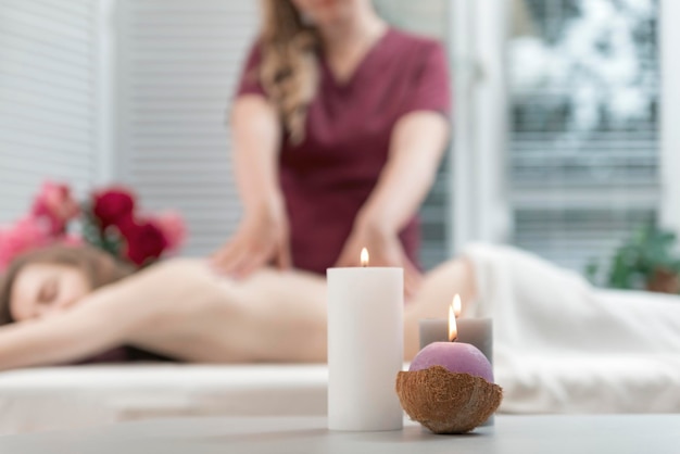 Candele profumate accese nel salone spa Massaggio alla schiena sullo sfondo Candele per creare un'atmosfera accogliente