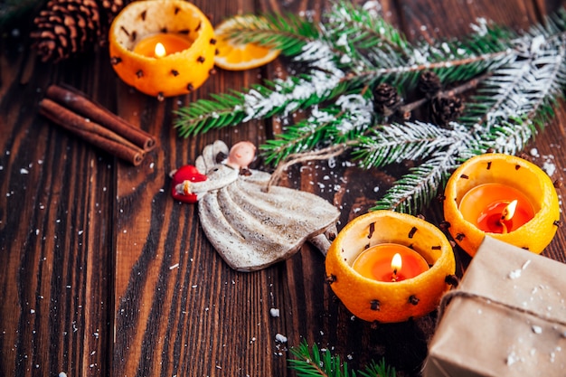 Candelieri fatti di mandarini con rami di abete, giocattoli e regali sul tavolo di legno. Natale e Capodanno