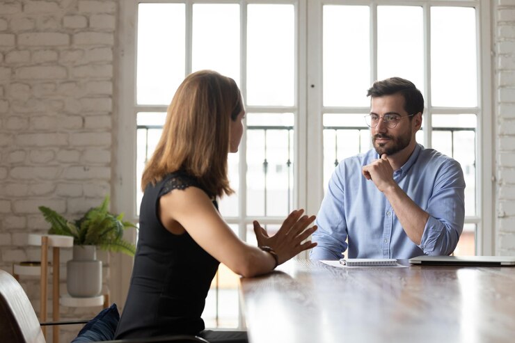 Foto candidata caucasica a un lavoro parla con un uomo d'affari di mezza età fa una buona prima impressione al colloquio in ufficio diversi partner commerciali concentrati parlano negoziano in riunione o briefing