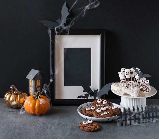 Candy bar di Halloween: mostri divertenti fatti di biscotti con cioccolato e fantasmi marshmelow vicino sul tavolo