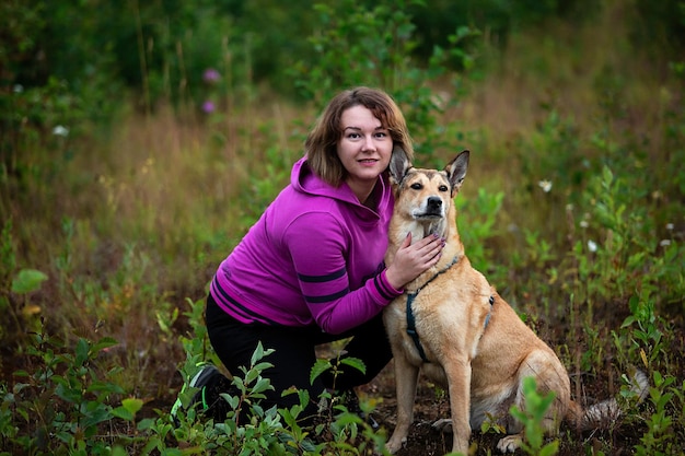 Cane di addestramento della donna in campagna nel campo