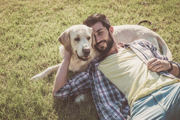 Cane labrador canadese che riposa nel parco con il suo proprietario in una giornata di sole