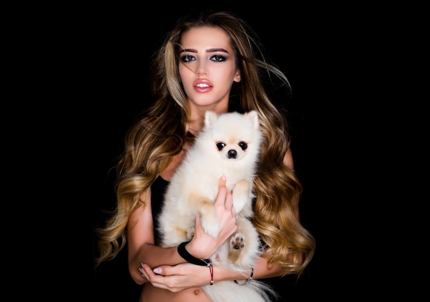 Cane o cucciolo di Pomerania Animale domestico carino cane da casa con donna di bellezza Donna con cane Ritratto di bella modella Modello di bellezza di alta moda Ragazza con trucco alla moda