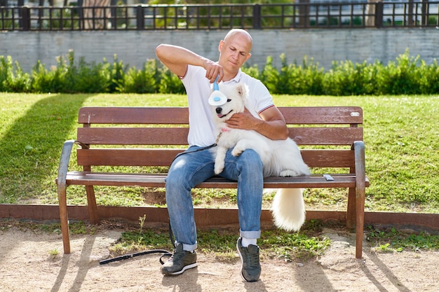 Cane Samoiedo con il suo proprietario al parco che giocano insieme