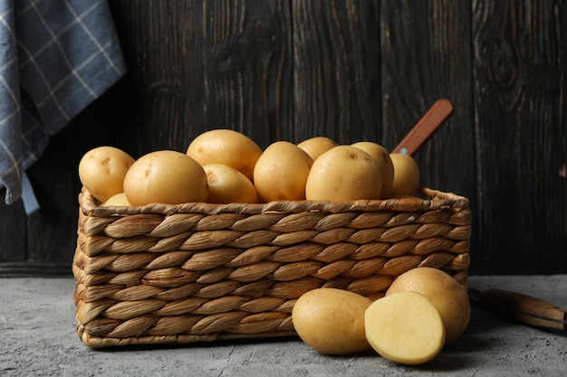 Canestro con le giovani patate su superficie grigia