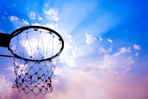 Canestro da basket visto dal basso sullo sfondo del bel cielo Una vista di un canestro da basket dal basso