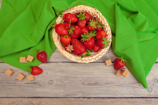 Canestro del raccolto della fragola sulla fine di legno della tavola su