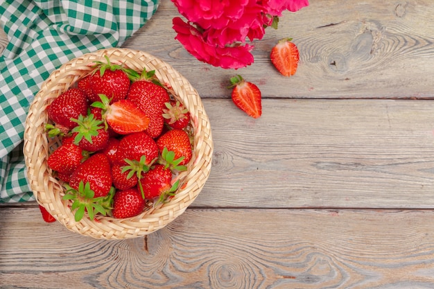 Canestro del raccolto della fragola sulla fine di legno della tavola su