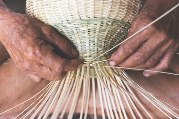 Canestro di bambù di tessitura di legno, canestro fatto a mano dei mestieri di lavoro della mano senior anziana dell&#39;uomo per il prodotto della natura in asiatico