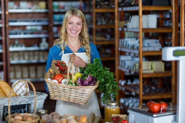 Canestro sorridente della tenuta del personale femminile delle verdure nella sezione organica